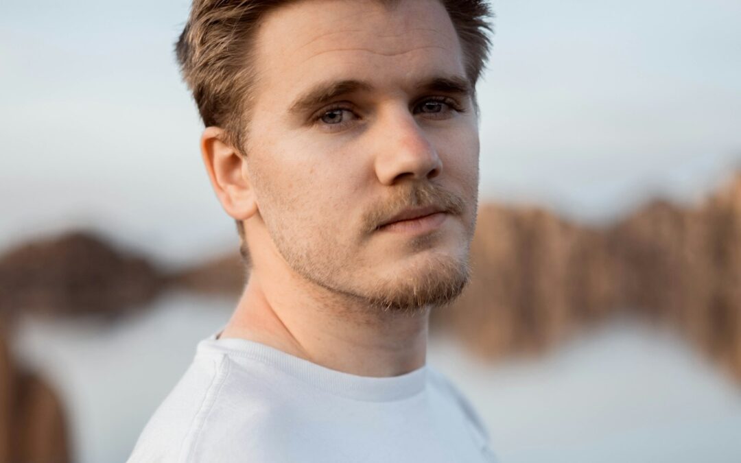 a man standing in front of a body of water