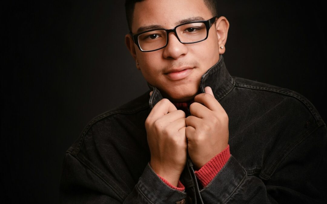 man wearing black denim jacket with black background